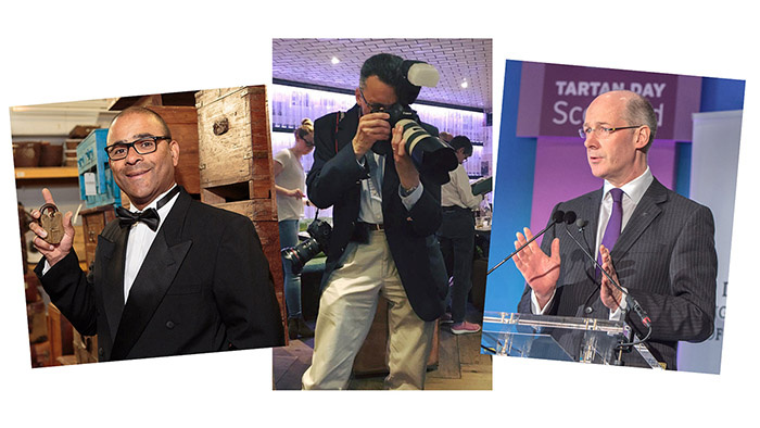 A man in dinner suit holding padlock, smiling, a man on dark blazer and tan trousers taking a photo with a DSLR and long lens and a balding male poitician speaking at a lectren.